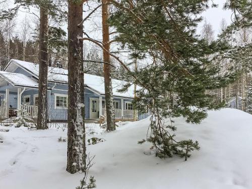 a house in the snow with trees at Holiday Home Nestori by Interhome in Vuoriniemi