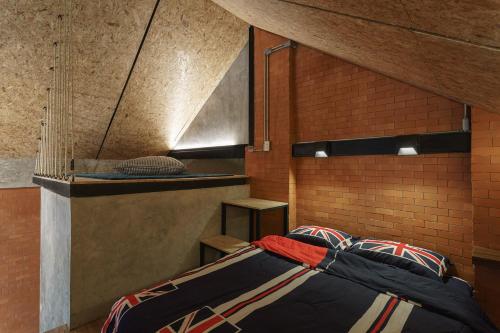 a bedroom with a bed and a brick wall at The Step Chiang Mai in Chiang Mai