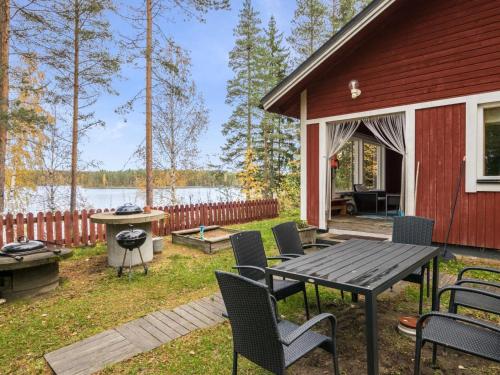 a backyard with a table and chairs and a grill at Holiday Home Aamuntorkku by Interhome in Vuoriniemi