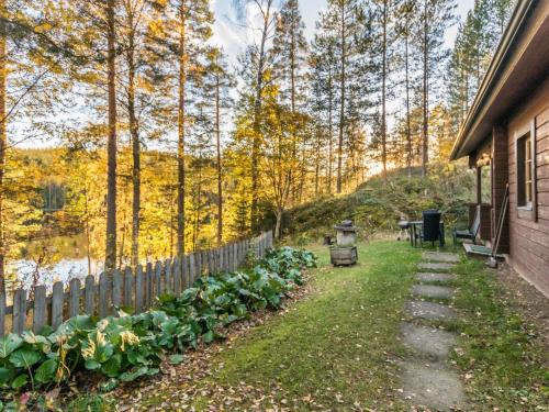 a garden next to a house with a fence at Holiday Home Suvituuli by Interhome in Vuoriniemi