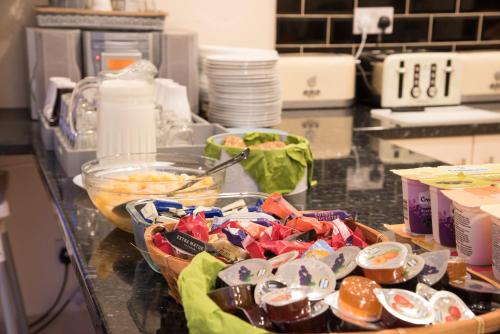 a kitchen counter with bowls of food on a table at Royal London Hotel By Saba in London