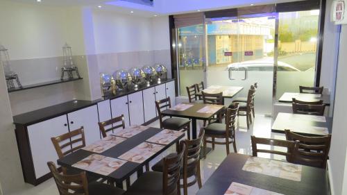 une salle à manger avec des tables et des chaises dans un restaurant dans l'établissement Al Jawhara Metro Hotel, à Dubaï