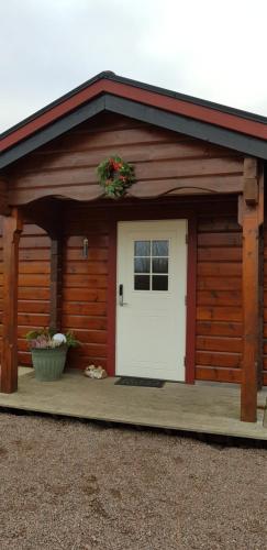 a large wooden garage with a white door at Good Morning Bed and Breakfast in Härslöv