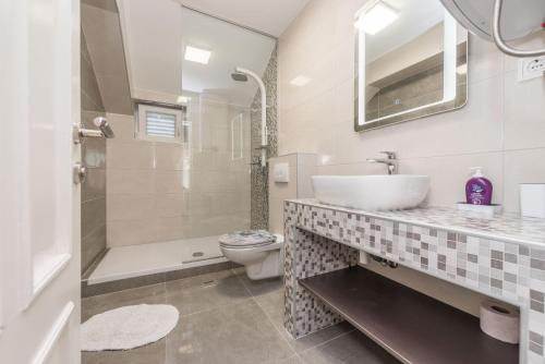 a bathroom with a sink and a toilet and a shower at Villa Zdenka in Pakoštane