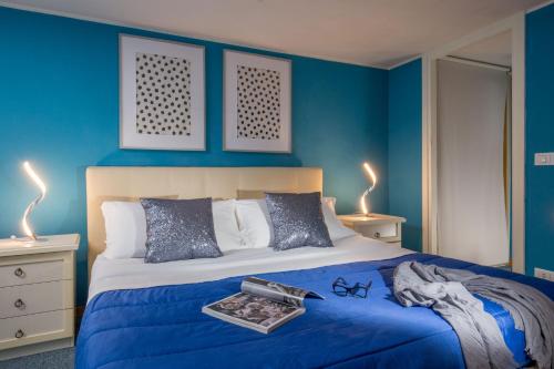 a blue bedroom with a bed and two lamps at Navona Blue Apartment in Rome