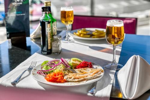 a table with a plate of food and two glasses of beer at Senator Parque Central in Valencia