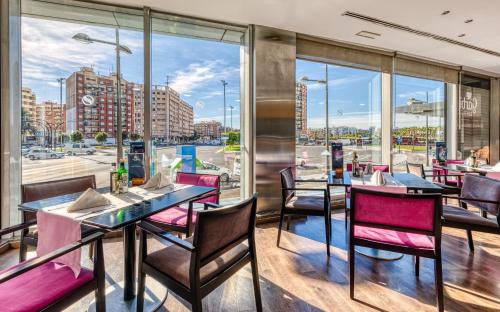 a restaurant with tables and chairs and a view of a city at Senator Parque Central in Valencia