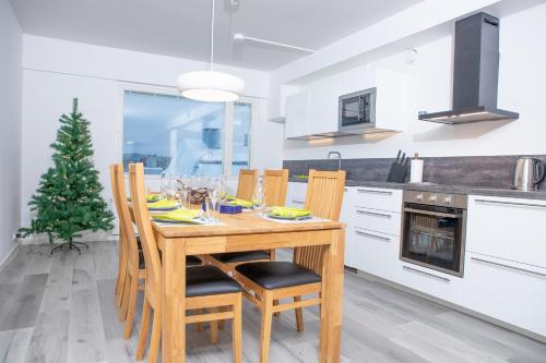 a kitchen with a wooden table with chairs and a christmas tree at Riverside Residences in Rovaniemi