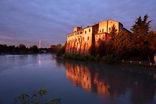 a building sitting on the side of a river at Castello Visconteo in Cassano dʼAdda