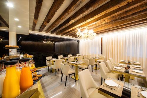a restaurant with tables and chairs and a chandelier at Palazzo San Lorenzo in Venice