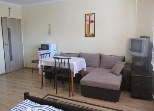 a living room with a couch and a table and a tv at Privat Mapak in Poprad