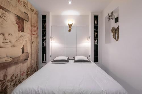 - une chambre avec un grand lit blanc et 2 oreillers dans l'établissement UnSejourAmetz-fr Meublés Ossons du T2 au T4 avec parking,, à Metz
