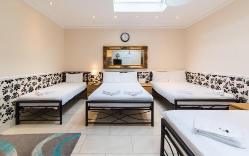 a room with three beds and a mirror at Royal London Hotel By Saba in London
