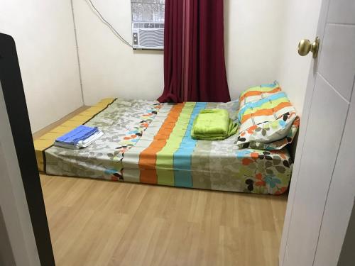 ein kleines Bett in einem Zimmer mit Fenster in der Unterkunft 3BR house @ Fiesta Village in Limay