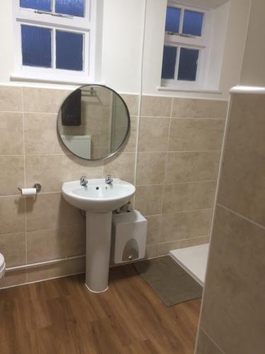 a bathroom with a sink and a mirror at Good Intent Rooms in Waltham Abbey