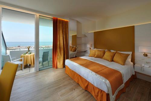 una camera con un grande letto e un balcone di Hotel Montecarlo a Bibione
