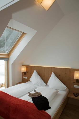 a bedroom with a white bed with a window at Sportappartements in Bad Mitterndorf