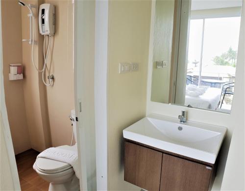 a bathroom with a sink and a toilet and a mirror at Top Hostel Samui in Chaweng