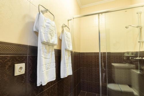 a bathroom with a glass shower and white towels at Belle Royalle in Lisarnya