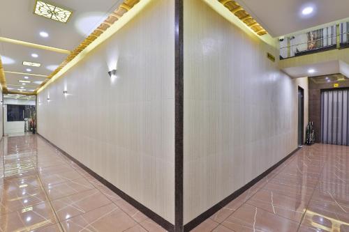 a corridor in a building with a white wall at Hotel Pearl in Vadodara