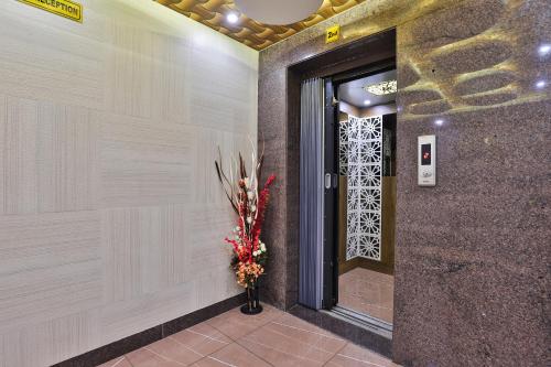a vase of flowers in front of a door at Hotel Pearl in Vadodara