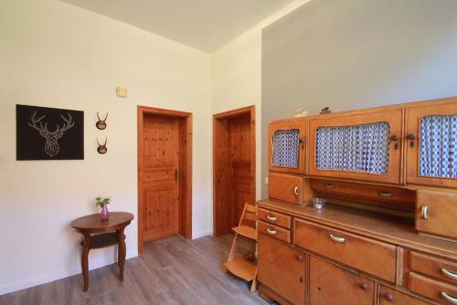 Zimmer mit einer großen Holzkommode und einem Tisch in der Unterkunft Ferienwohnung Am Sod - Familie Hennig in Rullstorf