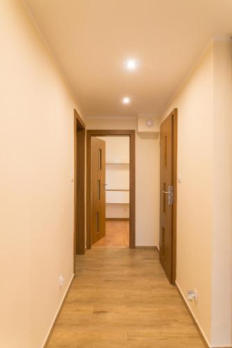 a hallway of an empty room with doors and wood floors at Apartament Na Urlop - Centrum - Przy Amfiteatrze - 500m do Basenów Wisła in Wisła