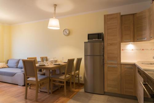 uma cozinha e sala de jantar com uma mesa e um frigorífico em Apartament Na Urlop - Centrum - Przy Amfiteatrze - 500m do Basenów Wisła em Wisla