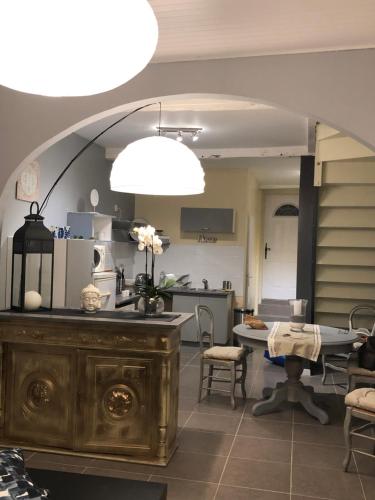 une cuisine avec un comptoir et une table avec des chaises dans l'établissement la Salaberie, à Villeréal