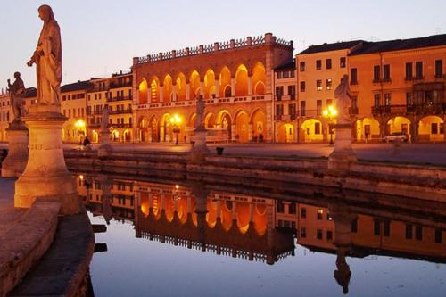 a building with a statue next to a body of water at Relais Alcova del Doge in Mira