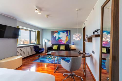 a room with a table and chairs and a bedroom at Radisson Blu Hotel Lietuva in Vilnius