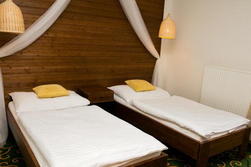 two twin beds in a room with wooden walls at Hotel Sharingham in Brno