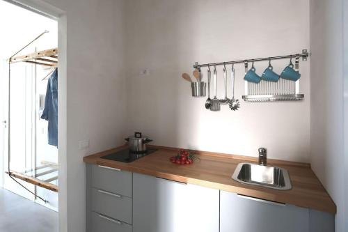 a kitchen with a sink and a counter with utensils at La Praya in Favignana