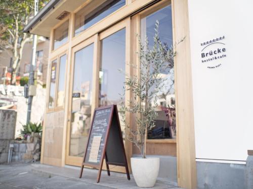 a building with a sign in front of a store at Brücke Arima KOBE in Kobe