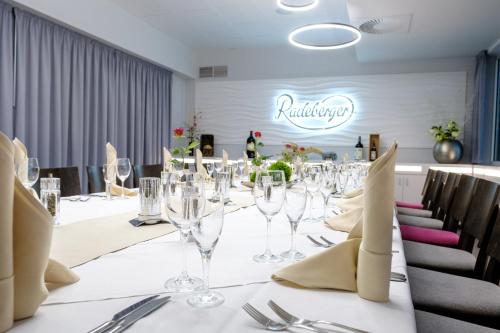 a long table with wine glasses and napkins at Hotel Sportwelt Radeberg in Radeberg