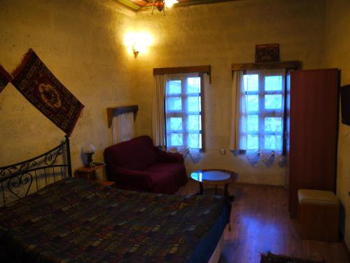 a bedroom with a bed and a couch and windows at Duru Hotel Cappadocia in Avanos