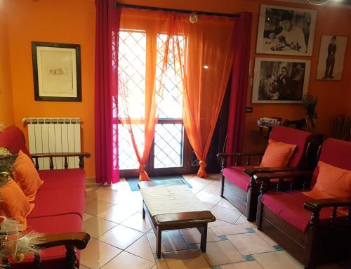 a living room with red couches and a window at B&B Vista su Roma in Marco Simone
