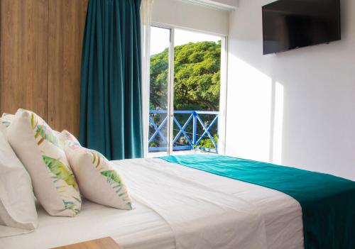 a bedroom with a large bed with a window at Hotel Avanti Chipichape in Cali