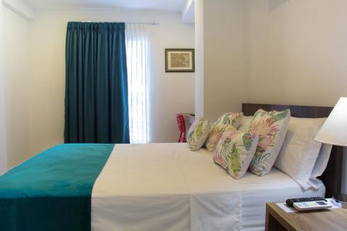 a bedroom with a bed with a blue curtain at Hotel Avanti Chipichape in Cali
