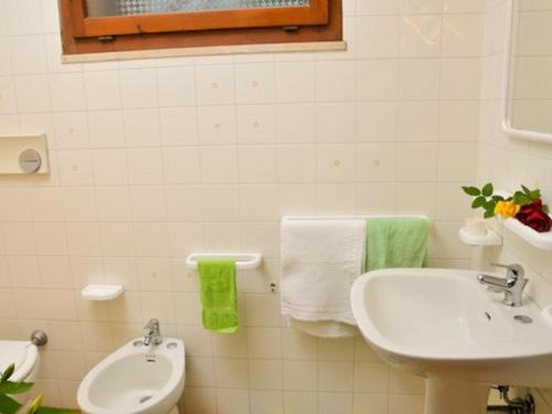 bagno bianco con lavandino e servizi igienici di Residence Il Vascello a Costa Rei