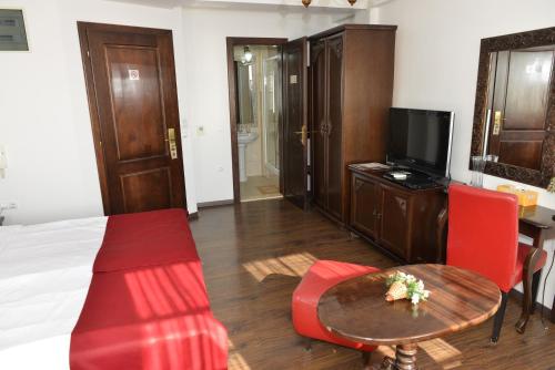 a hotel room with a bed and a table and chairs at Villa & Winery Mal Sveti Kliment in Ohrid