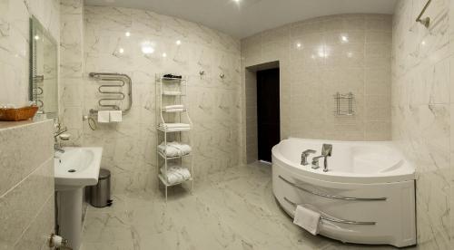 a white bathroom with a tub and a sink at Premier Hotel in Nizhny Novgorod