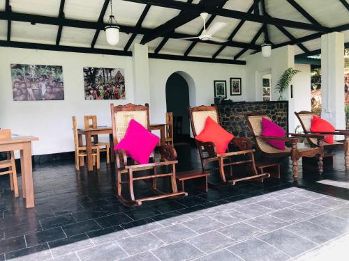 a group of chairs with colorful cushions in a room at Gammaduwa Heritage Bungalow and Tea Gardens in Matale
