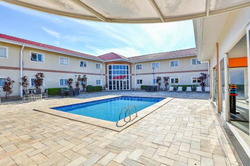 a swimming pool in front of a building at Nobile Inn Jundiaí in Jundiaí