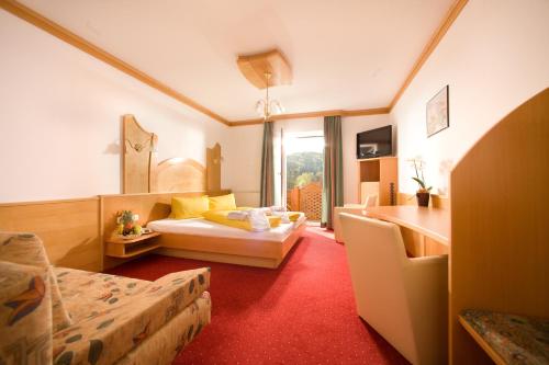 ein Hotelzimmer mit 2 Betten und einem Tisch in der Unterkunft Pension Drei-Mäderl-Haus in Unterlamm
