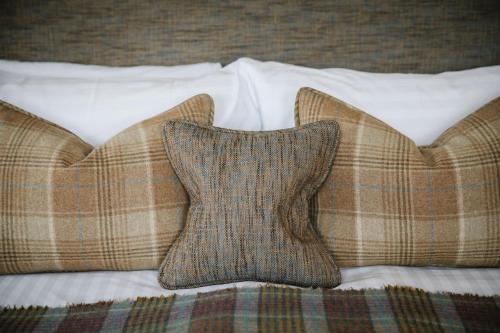 a bed with two pillows on a bed with a blanket at Lindeth Howe in Bowness-on-Windermere