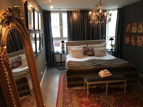 a bedroom with a large bed and a mirror at Karstorp Säteri – Hotell och Konferens in Skövde