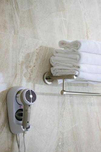 a towel rack with a hair dryer and a stack of towels at Walk in the Wind Homestay in Taitung City