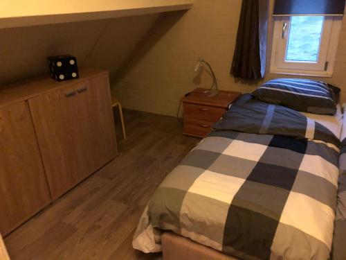 um quarto com uma cama e piso em madeira em Het Pronkje em Renesse