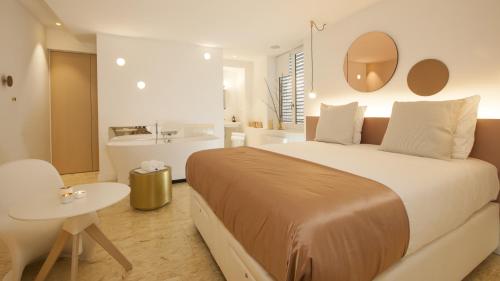 a bedroom with a large bed and a table at MiHotel Comte in Lyon